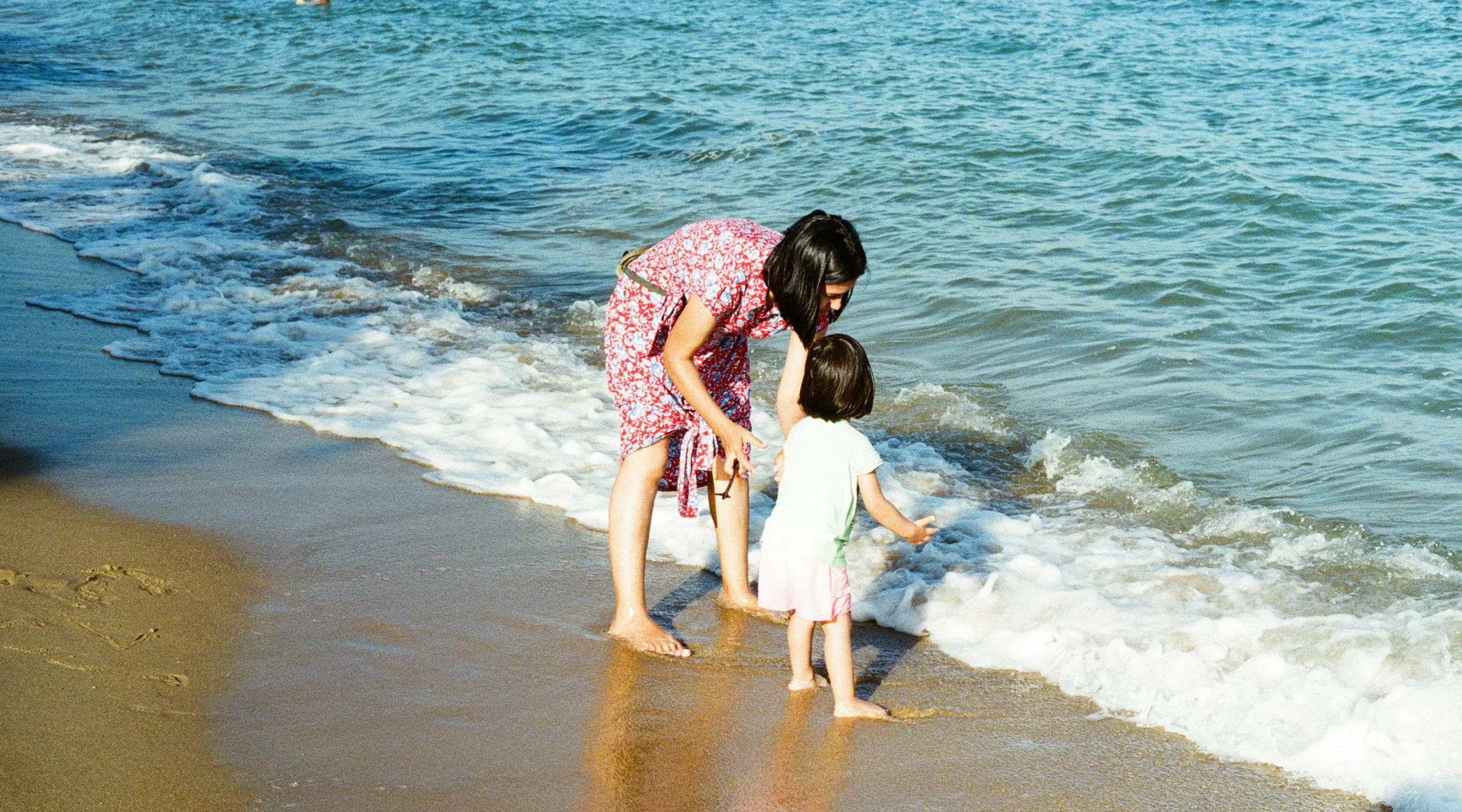 Femme avec un enfant jouant dans les vagues au bord de l