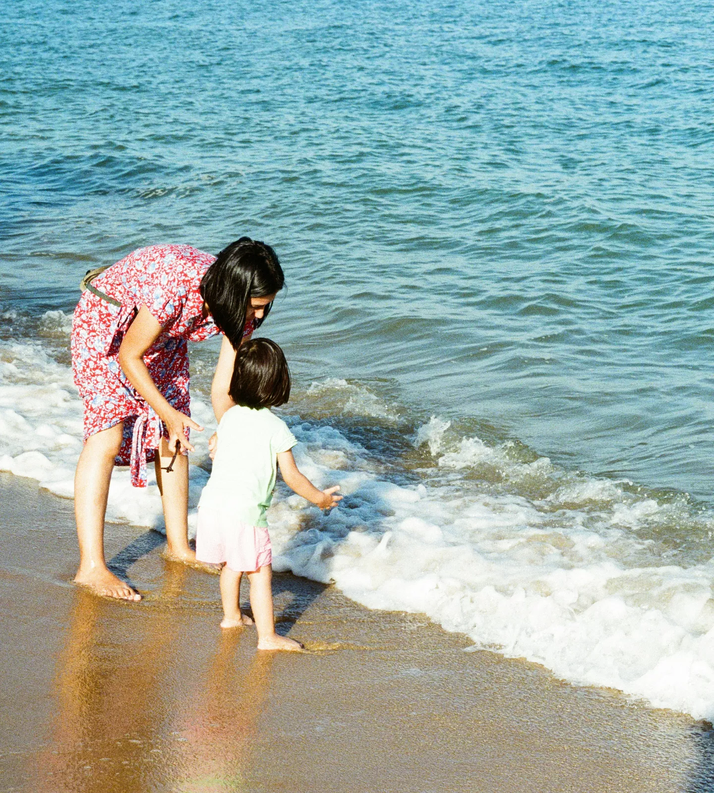 Femme avec un enfant jouant dans les vagues au bord de l