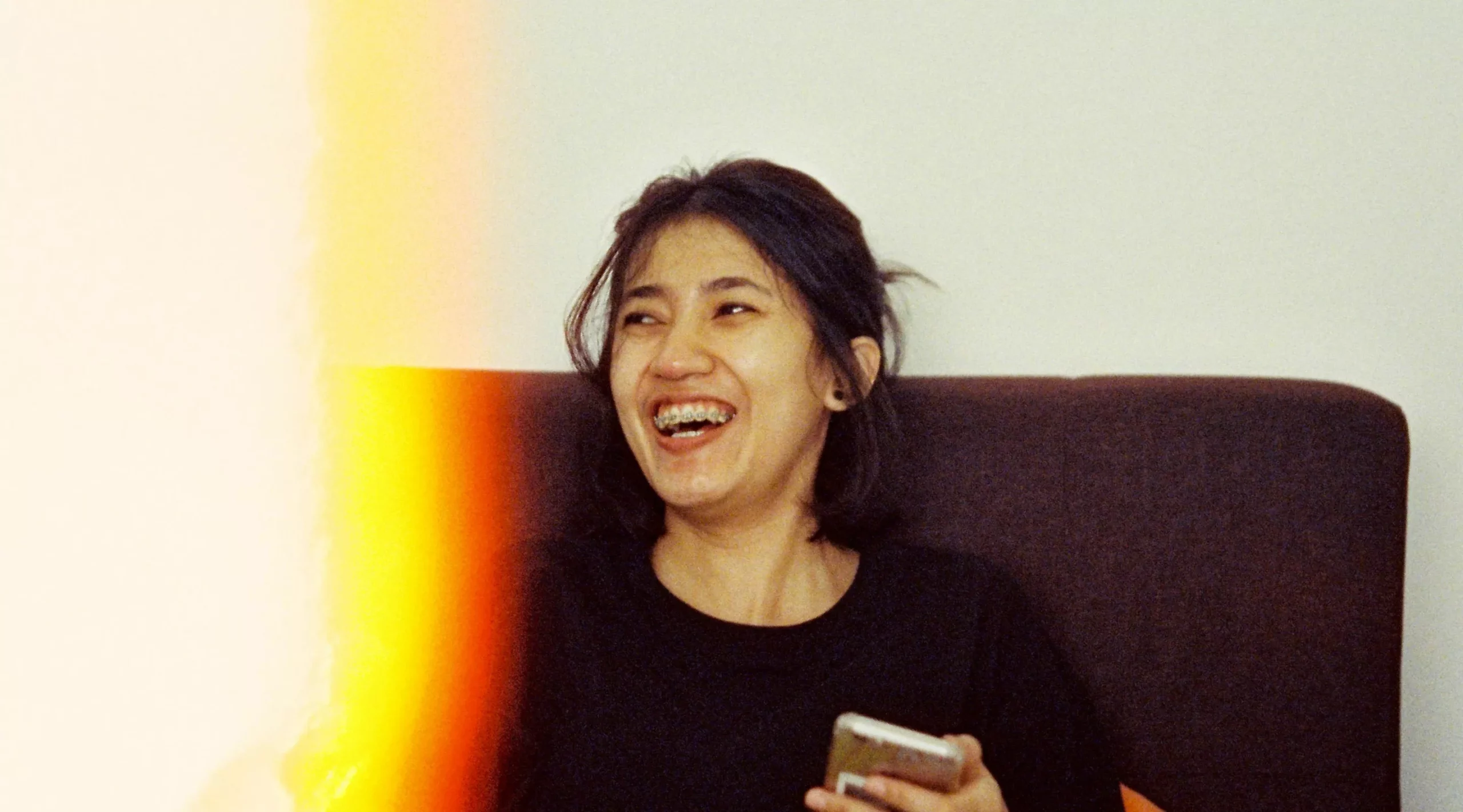 Femme riant sur un canapé