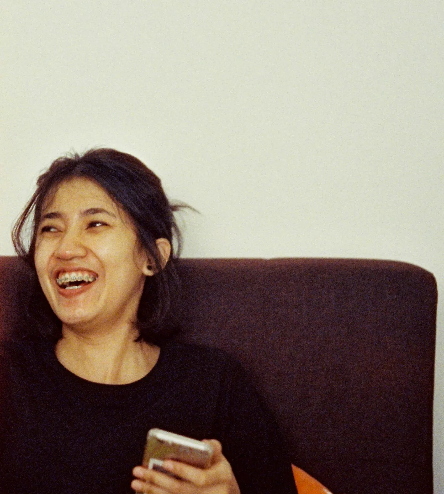 Femme riant sur un canapé