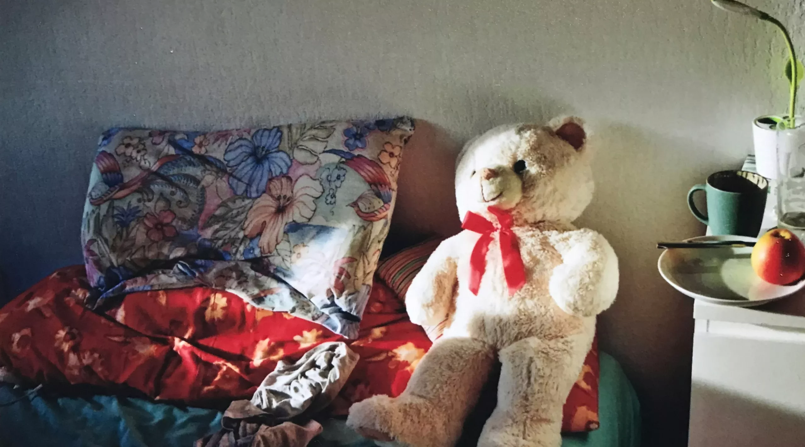 Peluche posée sur un lit défait