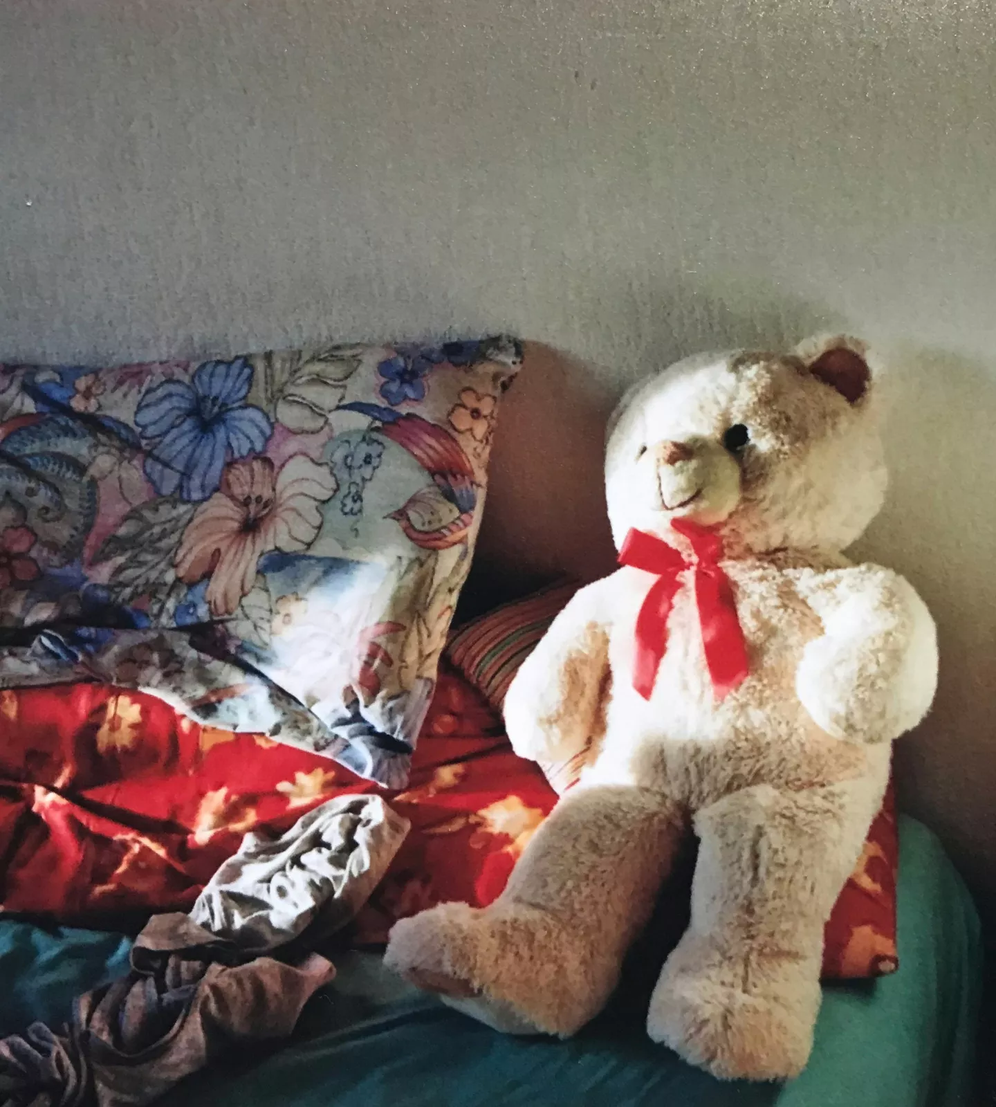 Peluche posée sur un lit défait